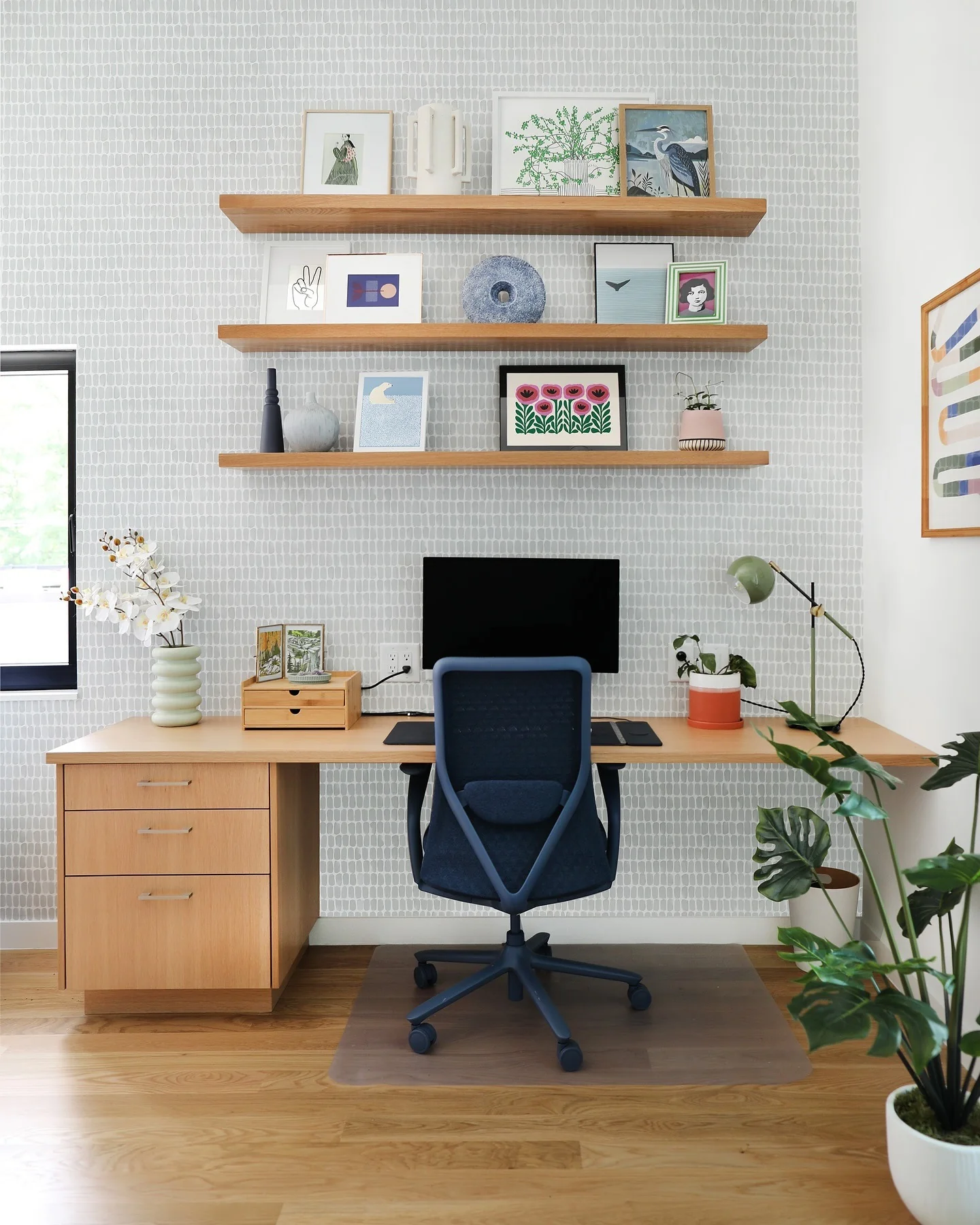 دفتر کار خانگی تازه با چوب روشن و آثار هنری شاداب